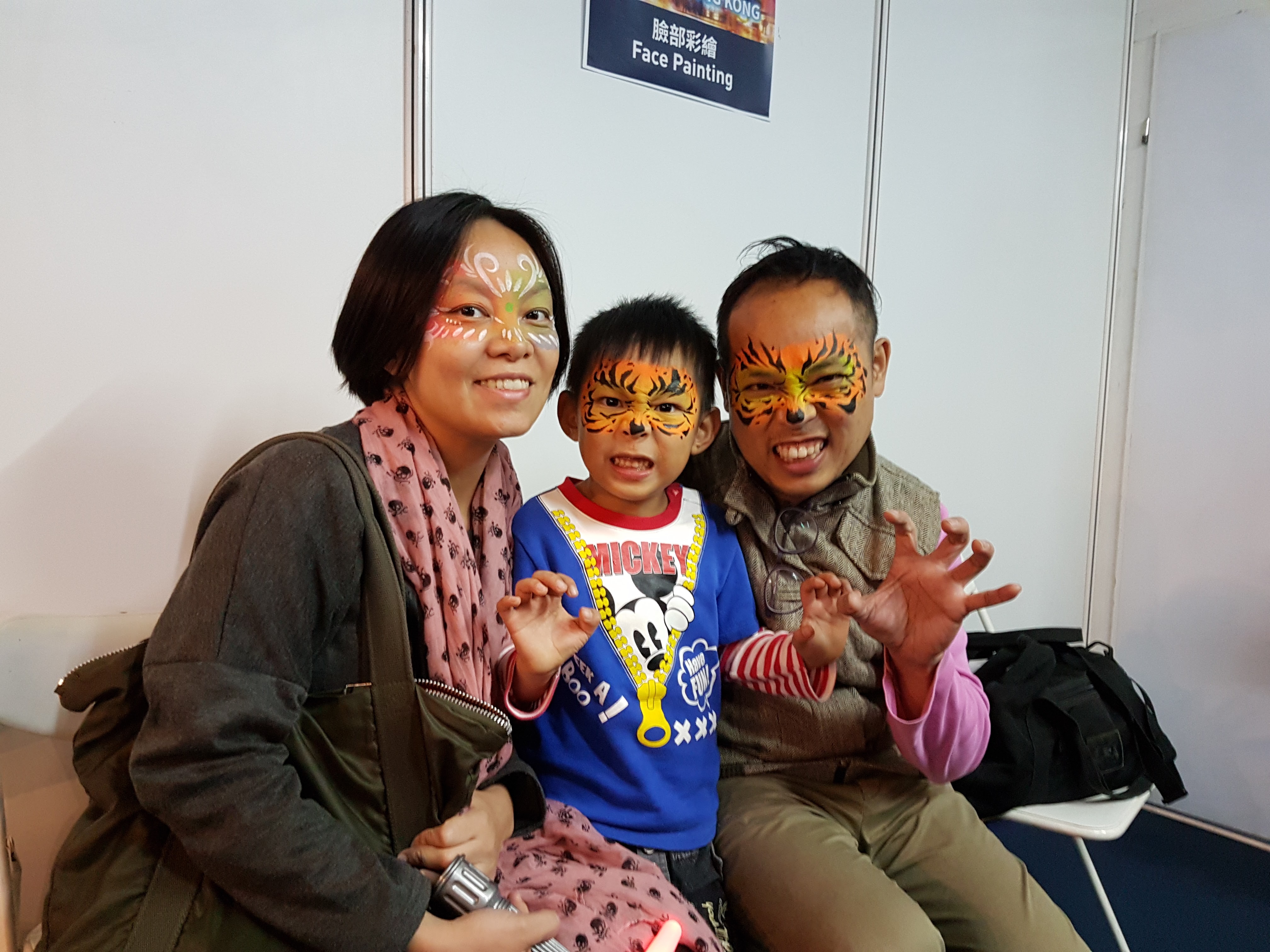 A family positing at the free face painting booth at Lumieres Hong kong